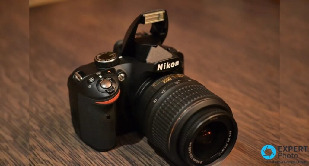  Nikon D3200 noir avec flash intégré relevé, témoin LED orange à côté du déclencheur, objectif 18-55mm 