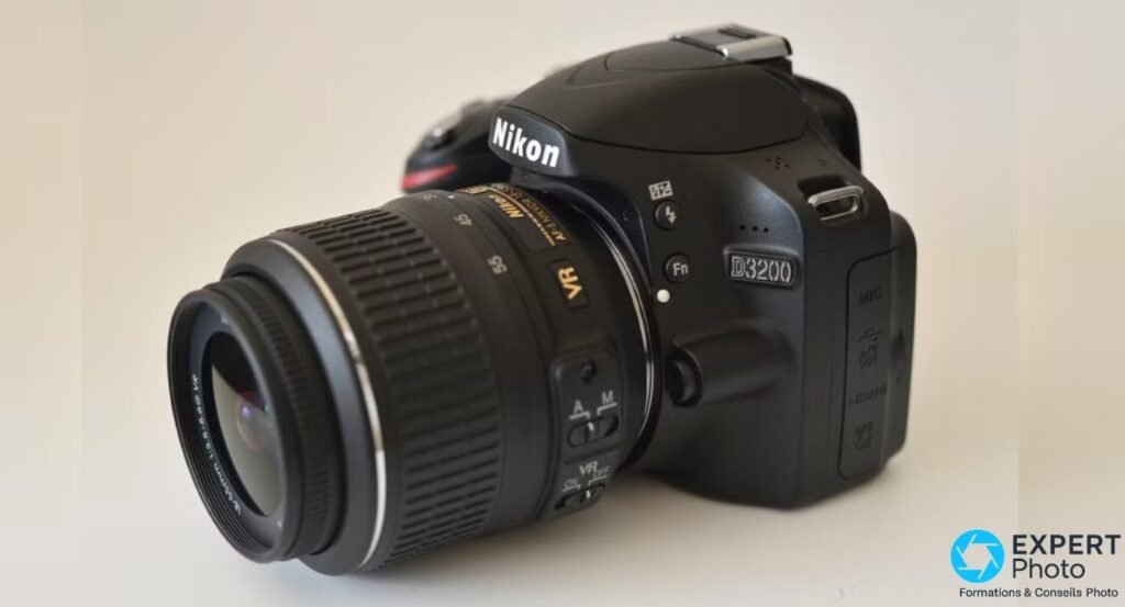 Nikon D3200 noir avec objectif Nikkor AF-S DX 18-55mm VR monté, sur fond studio beige uniforme 