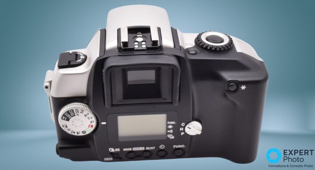  Canon EOS IX Lite argentique, dos face, viseur reflex, écran LCD, molette AV/TV/P, sélecteur C/H/P, hot shoe, fond teal 