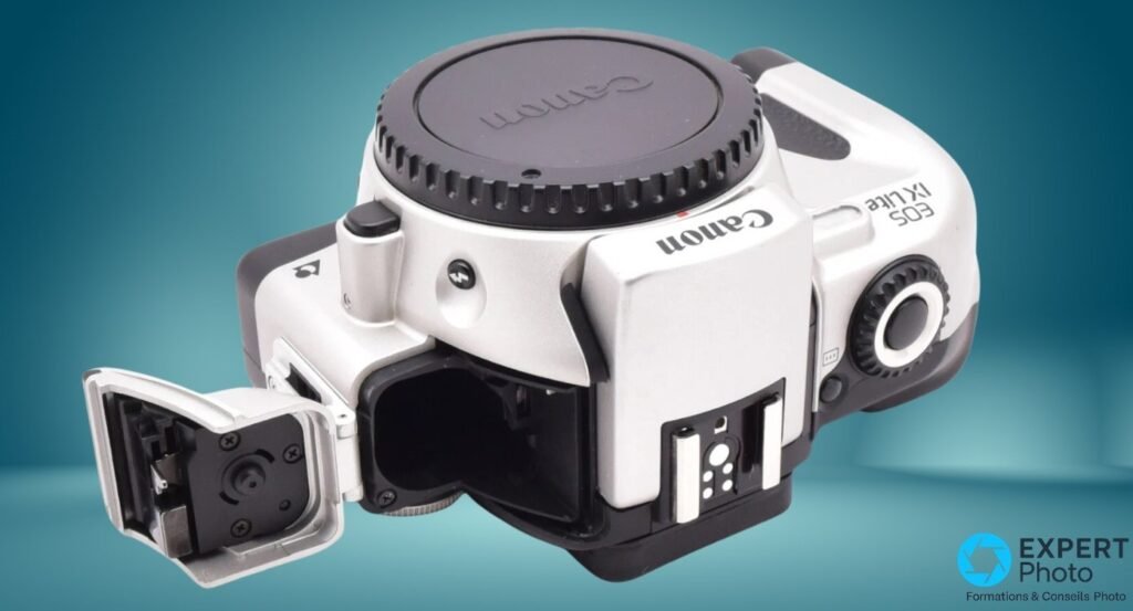 Canon EOS IX Lite argentique, vue inclinée de dessus, trappe compartiment cartouche APS ouverte, bouchon monture EF Canon visible