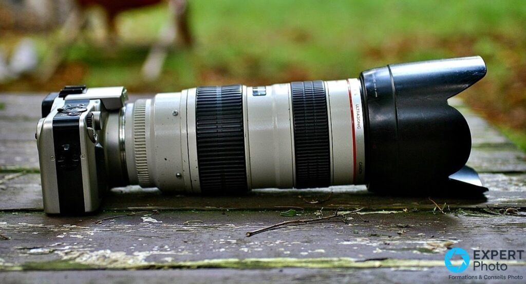 Canon EOS IX de profil avec objectif Canon EF L Ultrasonic blanc monté et pare-soleil pétale noir