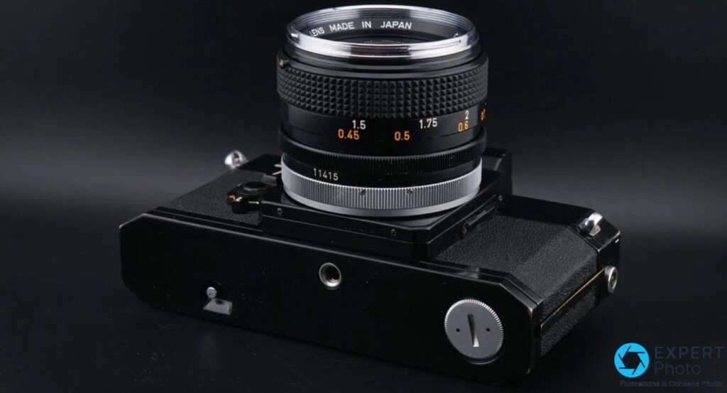 Canon F-1 vu en plongée par le dessous, semelle avec pas de vis, bague mise au point FD avec graduations 0,45 à 2 m visibles