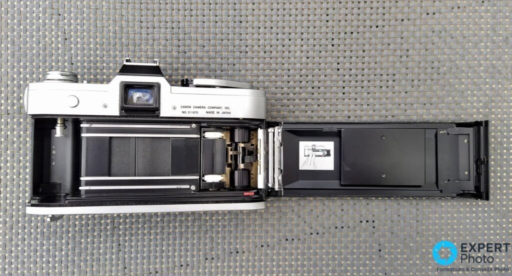 Canon FT QL dos ouvert révélant le compartiment pellicule avec rideaux d'obturateur et mécanisme QL de chargement.