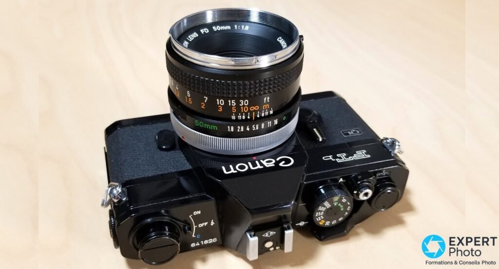 Canon FTb-N vu de dessus, objectif FD 50mm f/1.8 monté, molette vitesses et sélecteur ON/OFF de la plaque supérieure