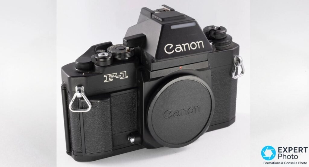 Canon New F-1 boîtier noir mat, trois quarts gauche, bouchon Canon monté, AE Finder FN en place, marquage F-1 visible