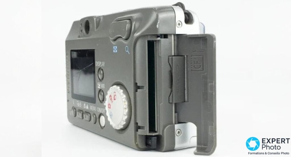Canon PowerShot A10 vue de dos et côté, trappe CompactFlash Type I ouverte révélant le logement de carte, fond blanc.