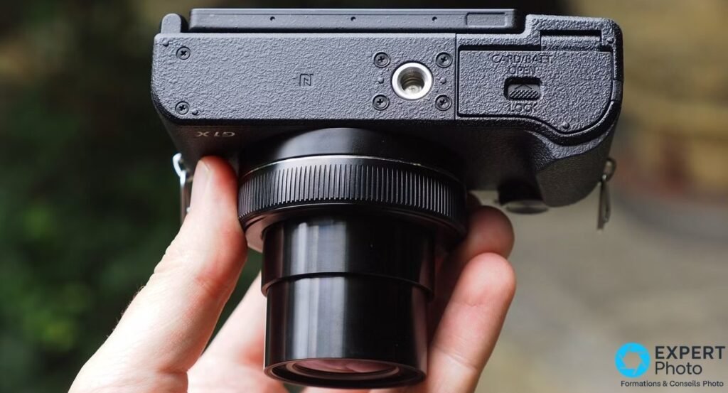 Canon PowerShot G1 X Mark III vu par le dessous, logo NFC visible, vis de pied filetée centrale, trappe CARD/BATT avec verrou