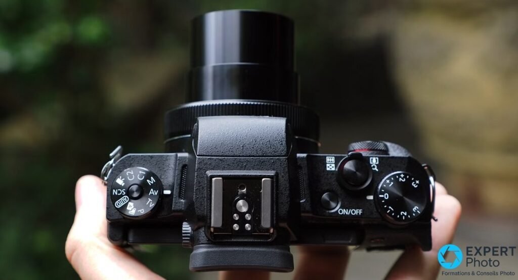 Canon PowerShot G1 X Mark III vu de dessus, molette de modes P/Av/Tv/M/SCN, sabot flash central et molette correction EV