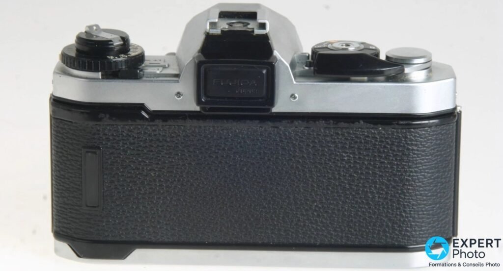 Fujica AX-1 vu de dos : oeilleton de visée rectangulaire avec inscription Fujica, levier de rebobinage à droite