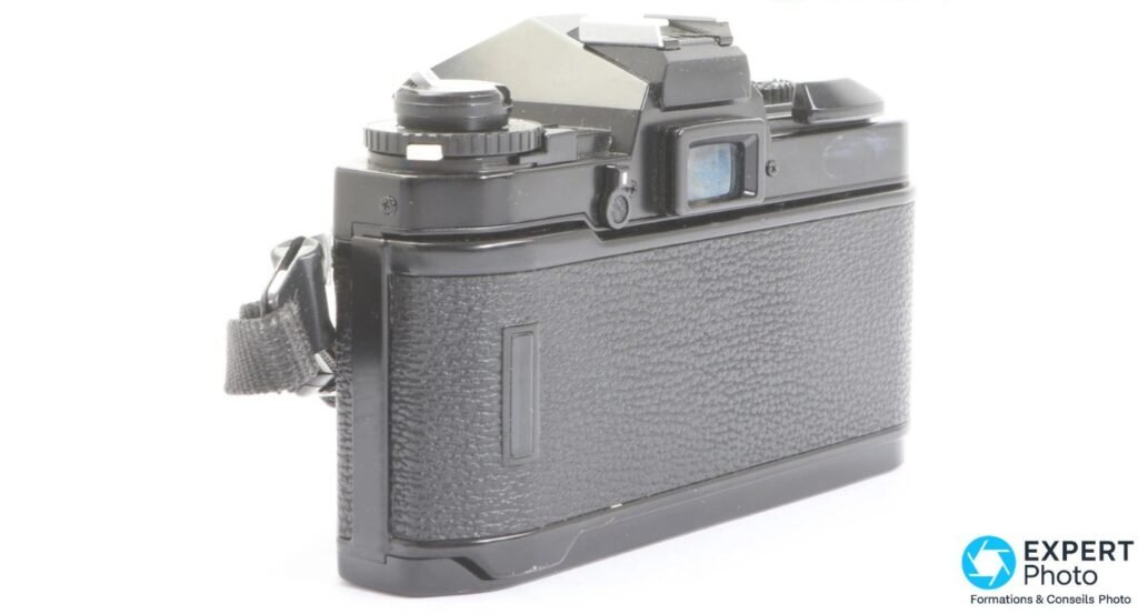 Fujica AX-3 noir vu de côté arrière, oculaire du viseur, dos lisse avec loquet d'ouverture et sangle noire