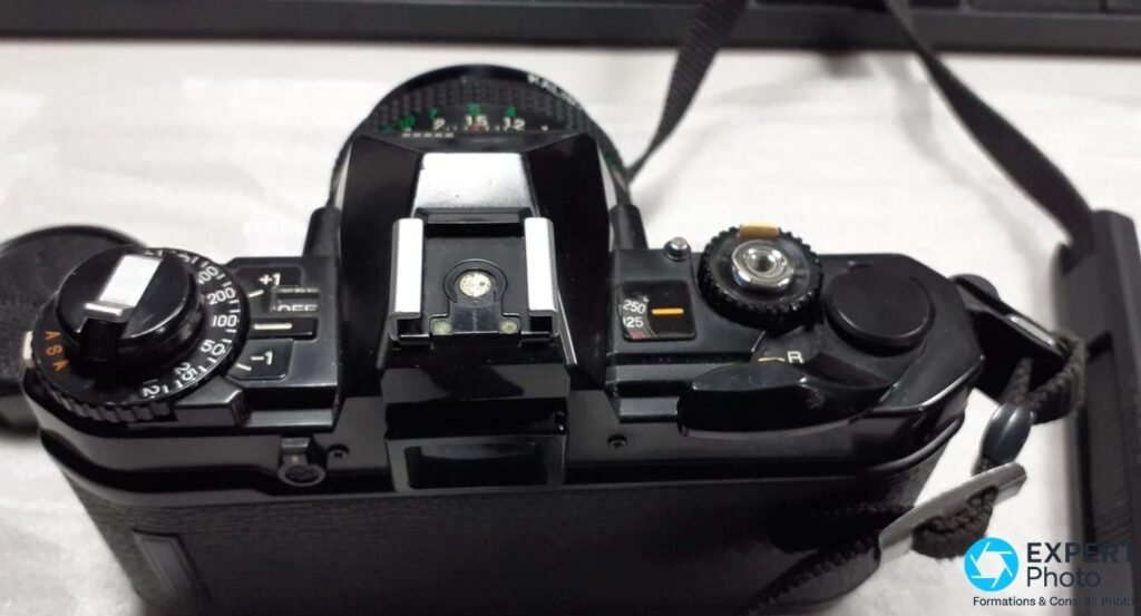 Fujica AX-5 noir vu de dessus : sélecteur ASA, correcteur expo, griffe flash centrale et molette de vitesses