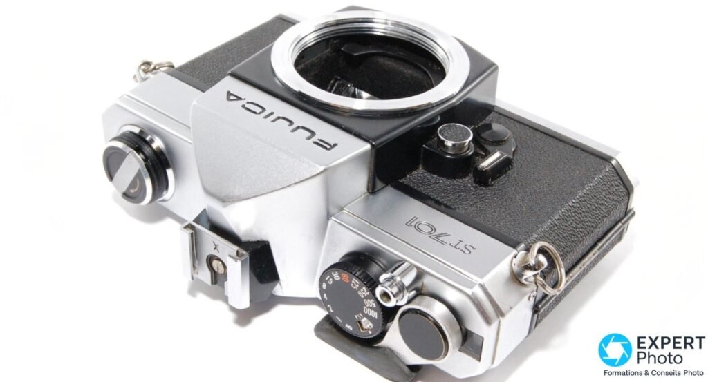Fujica ST701 argentique boîtier nu vu de dessus en oblique, monture M42 à vis ouverte et molette des vitesses visible