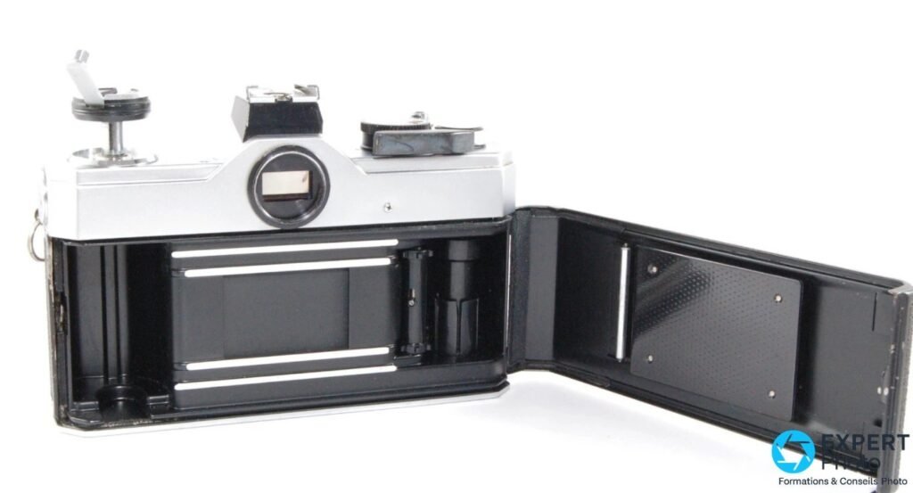 Fujica ST701 boîtier ouvert vu de dos en trois quarts, chambre film noire avec rails et rideaux de l'obturateur