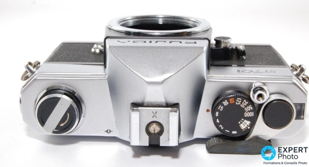 Fujica ST701 vu de dessus : molette des vitesses (60 en orange), griffe flash X et levier d'armement