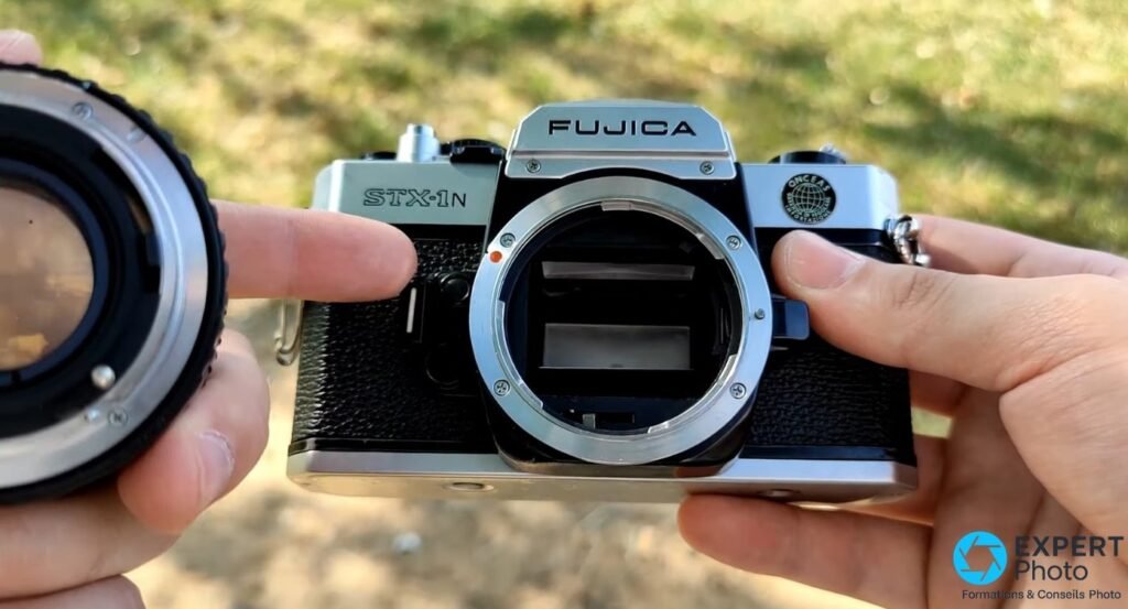 Fujica STX-1N sans objectif, monture Fujica X ouverte face caméra, inscription STX-1N lisible, objectif détaché à gauche