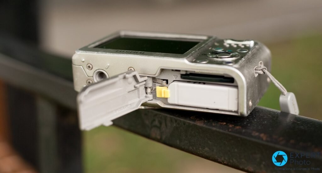 Fujifilm FinePix F31fd vue de dessous, trappe ouverte révélant la batterie NP-95 blanche et le slot carte xD 