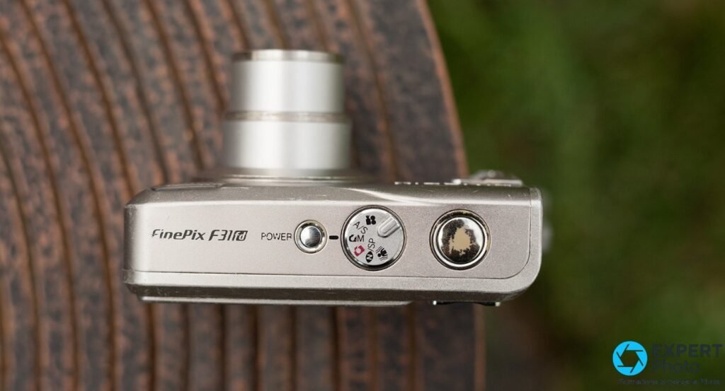 Fujifilm FinePix F31fd vue du dessus, gravure FinePix F31fd, molette modes A/S/M/SP, bouton Power, déclencheur 