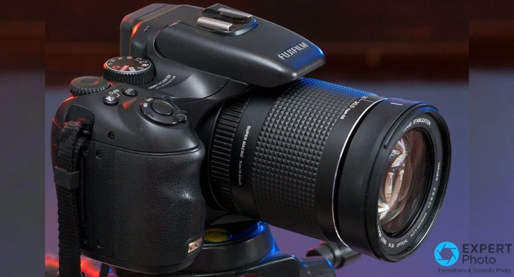 Fujifilm FinePix S200EXR en vue trois quarts, objectif zoom Fujinon déployé, grip texturé visible