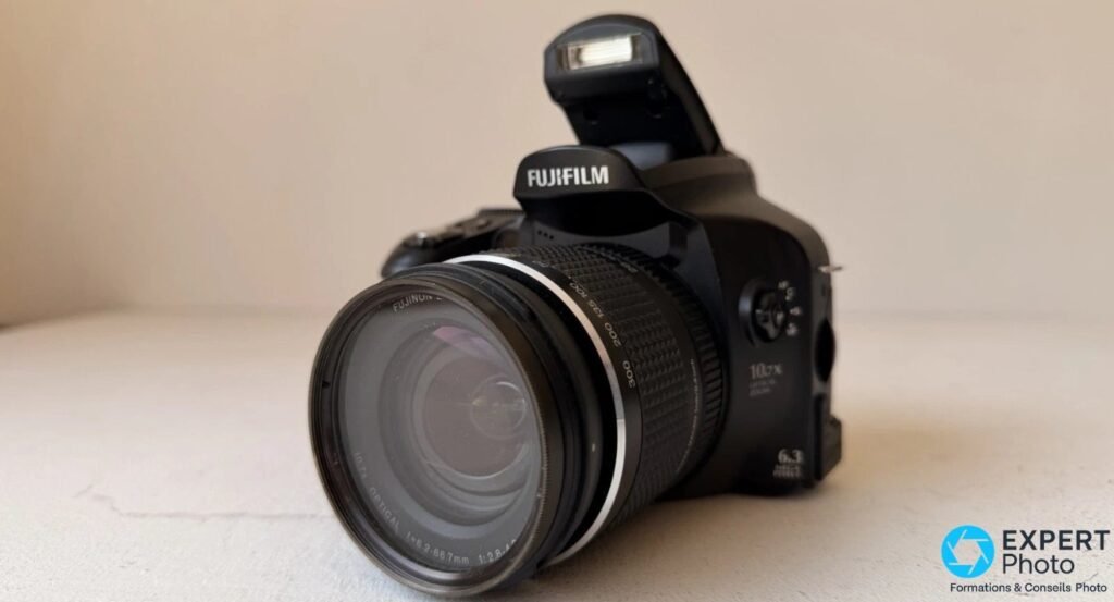 Face avant du Fujifilm FinePix S6500fd avec flash intégré relevé et objectif Fujinon 10,7x 6,3 Mpx apparent