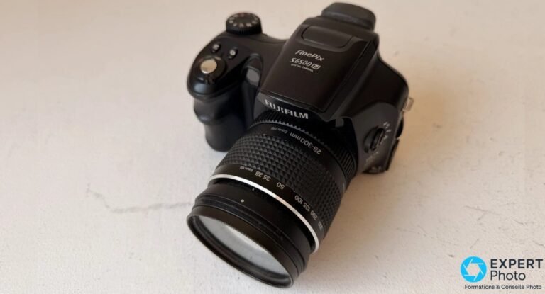 Bridge Fujifilm FinePix S6500fd photographié trois-quarts de dessus, zoom 28-300 mm déployé et graduations visibles