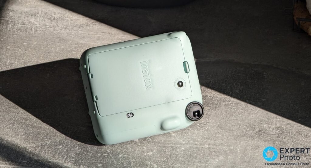 Fujifilm Instax Mini 12 vert menthe vu de dos avec capot du compartiment film et compteur de vues affichant 10
