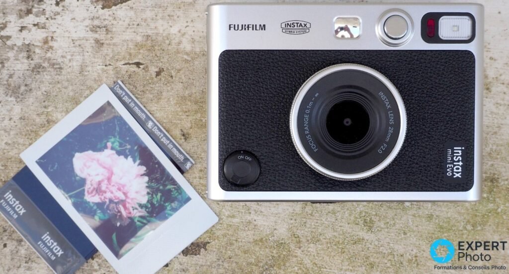 Fujifilm Instax Mini Evo vu de dessus avec pack film Instax Mini et tirage photo de fleur rose