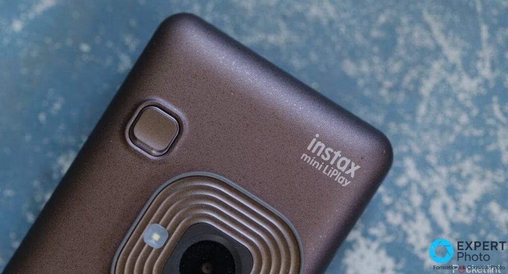 Gros plan face avant Instax Mini LiPlay marron : objectif concentrique, flash et logo instax mini LiPlay