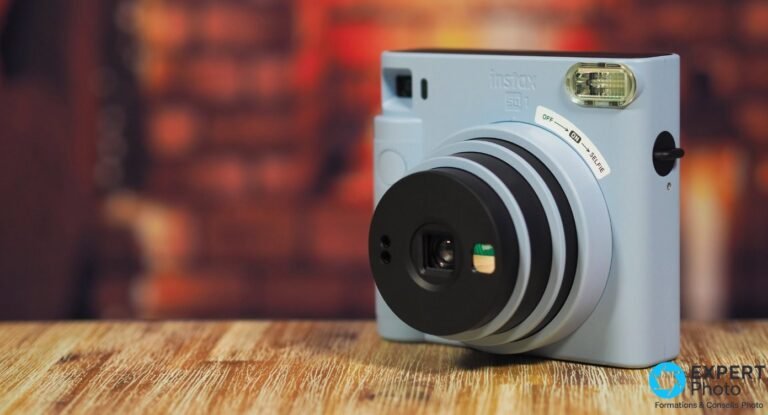 Test Fujifilm Instax Square SQ1 : le carré instantané sans prise de tête Fujifilm Instax Square SQ1 bleu glacier, vue trois quarts avant, objectif rotatif, flash intégré et inscription ON/SELFIE visibles