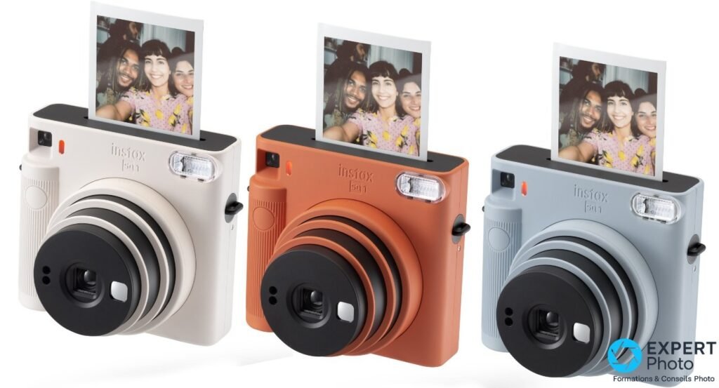 Trois Fujifilm Instax Square SQ1 côte à côte en blanc, orange et bleu glacier, chacun avec un tirage carré éjecté par le haut