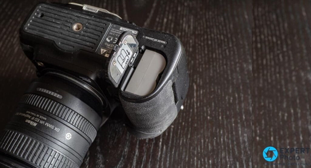 Fujifilm S5 Pro retourné, trappe batterie ouverte sur la NP-150 grise, pas de vis trépied et mention Made in Japan visibles.