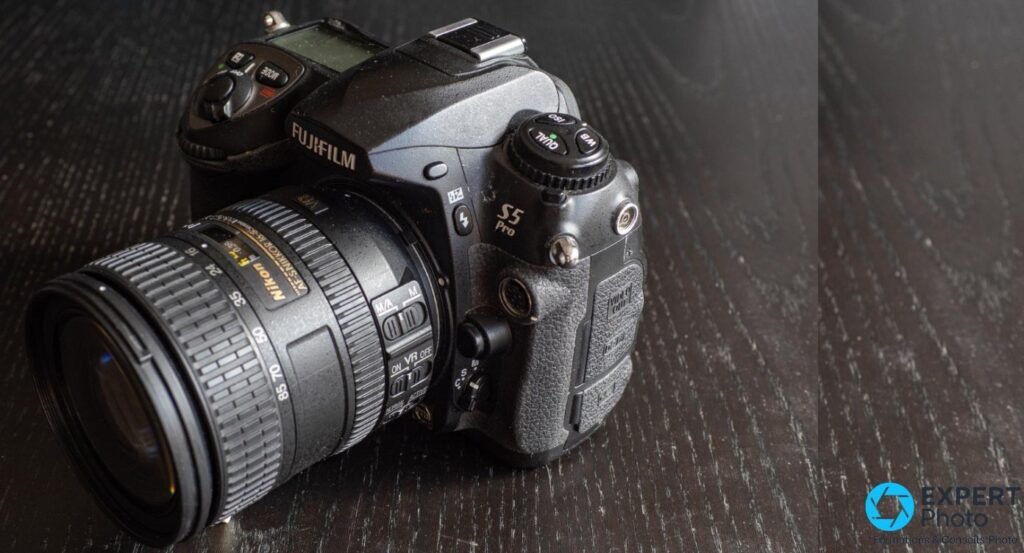 Fujifilm S5 Pro vu de face et de gauche, zoom Nikon AF-S Nikkor 16-85mm DX VR monté, marquage S5 Pro visible sur le flanc.