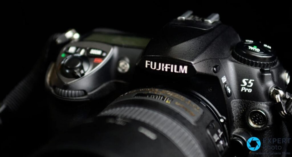 Gros plan du sommet du Fujifilm S5 Pro, logo FUJIFILM blanc et inscription S5 Pro lisibles, fond noir studio.