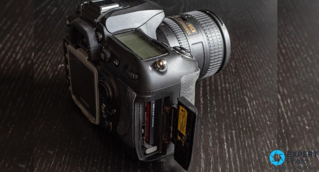 Fujifilm S5 Pro de dessus, trappe CompactFlash ouverte, carte CF jaune partiellement insérée, zoom Nikon DX monté.