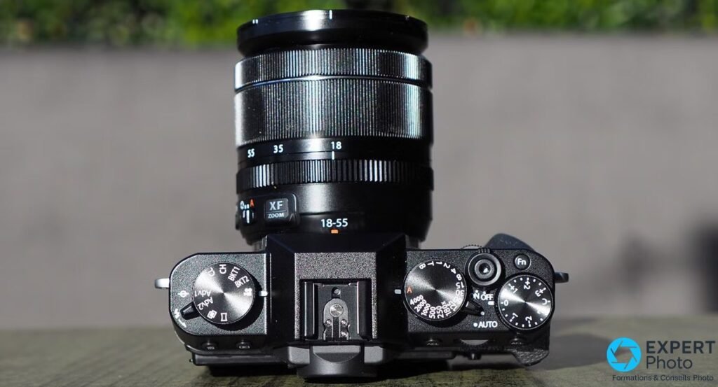 Fujifilm X-T30 vu de dessus, molettes physiques de vitesse, drive et correction d'exposition, zoom XF 18-55 monté