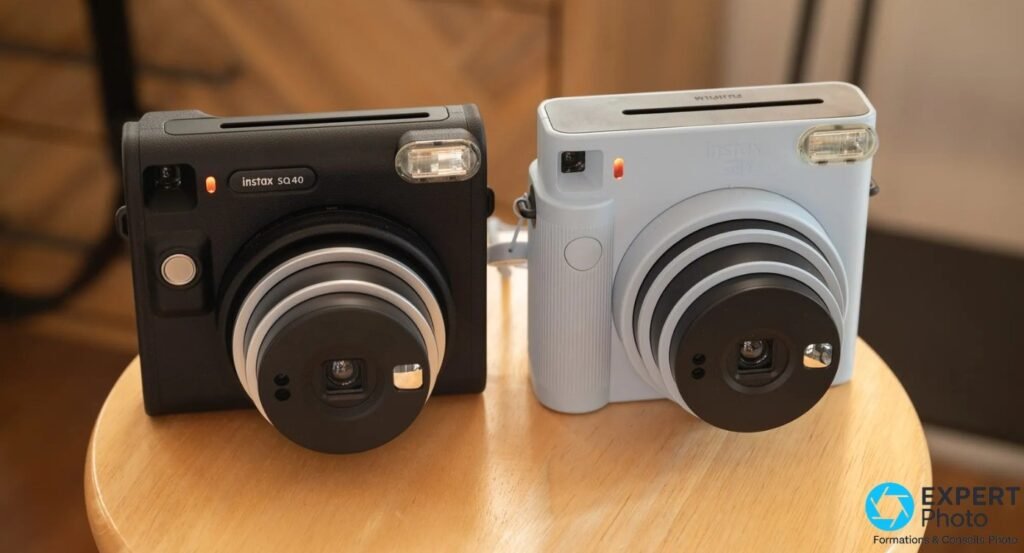 Fujifilm Instax SQ40 noir à gauche et SQ1 blanc-bleu à droite, côte à côte sur une table, comparaison des deux modèles