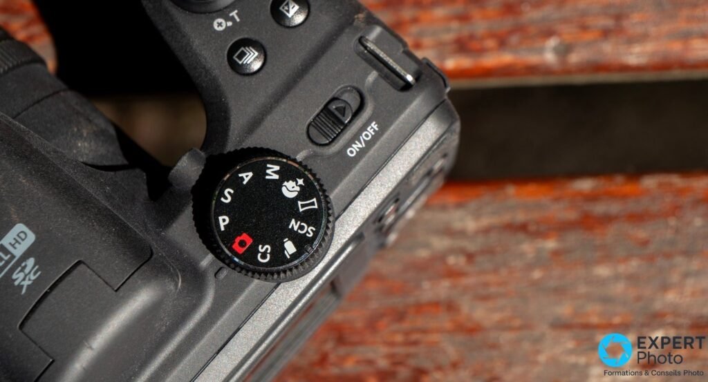 Gros plan sur la molette de modes de la Kodak AZ405 : positions M, A, S, P, SCN, vidéo, scènes ; bouton ON/OFF visible. 