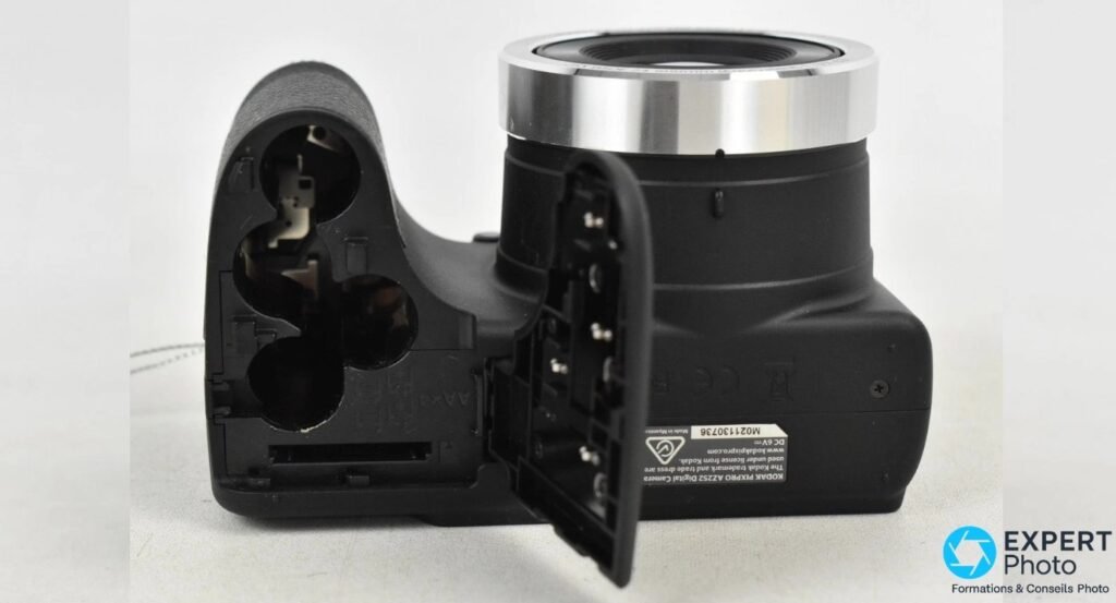 Kodak Pixpro AZ252 vu de dessous, trappe ouverte révélant 4 emplacements piles AA et le slot carte SD