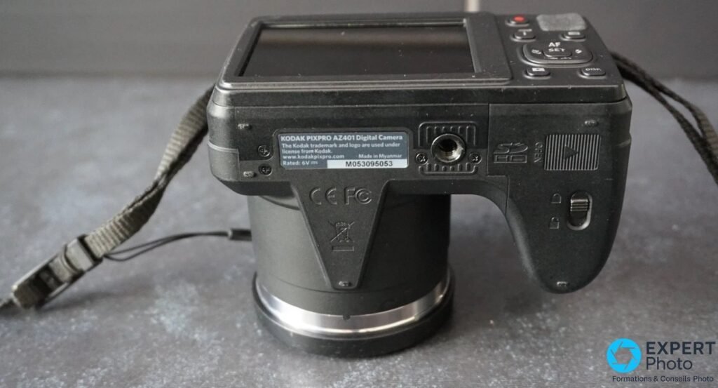 Kodak Pixpro AZ401 vu de dessous, étiquette Made in Myanmar, numéro série M053095053, pas de vis trépied, marquages CE FCC