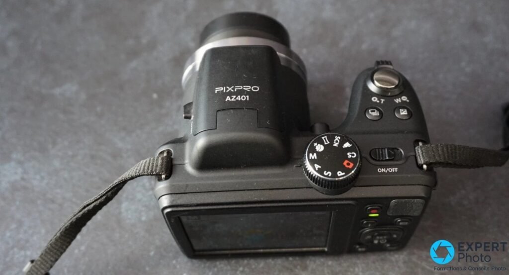 Kodak Pixpro AZ401 vu de dessus, molette PASM SCN II lisible, bouton ON/OFF, touches zoom T et W, inscription PIXPRO AZ401