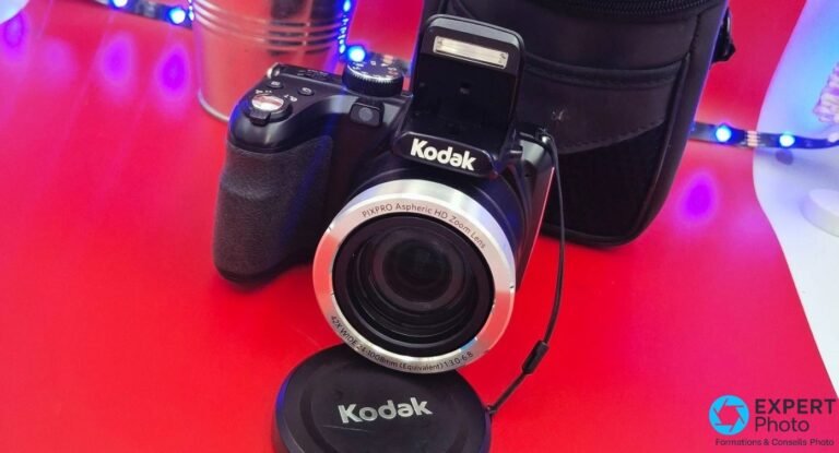 Test Kodak PIXPRO AZ422 : zoom puissant, limites assumées Kodak PIXPRO AZ422 noir de face, flash relevé, objectif zoom 42x 24-1008mm visible, capuchon et housse en arrière-plan