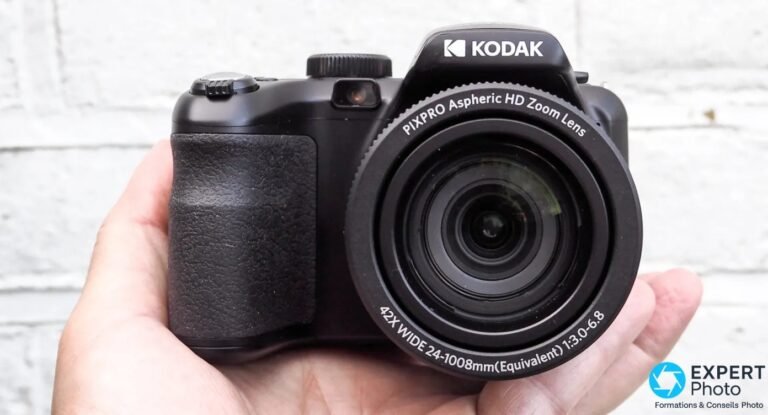 Kodak PIXPRO AZ425 face avant sur pierre, objectif 42x Wide en grand-angle, flash pop-up ouvert, molette modes visible