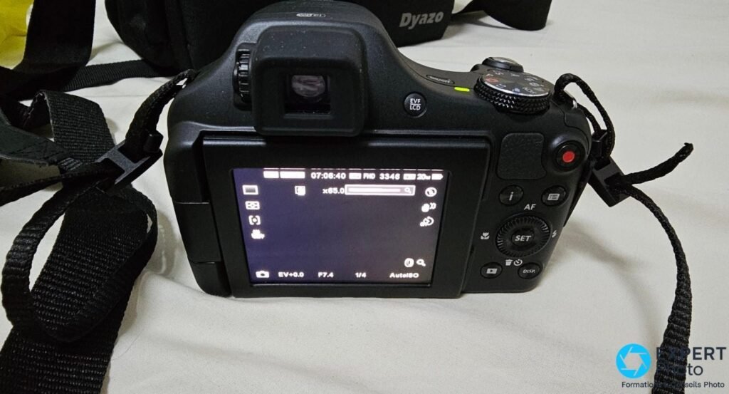 Kodak PIXPRO AZ652 face arrière, écran LCD affichant zoom x65, F7.4, 1/4s, AutoISO, FHD, boutons EVF, AF, SET, DISP visibles 