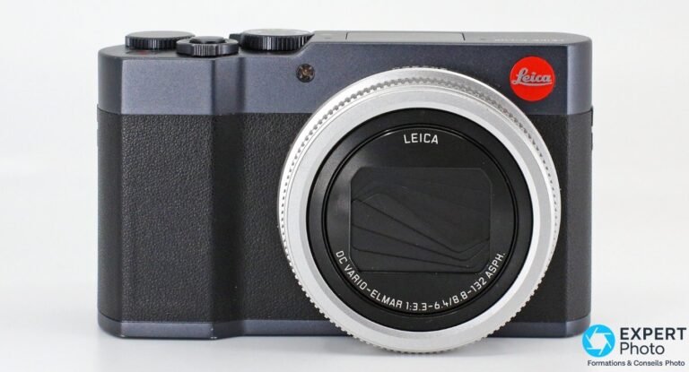 Leica C-Lux de trois-quarts face, flash escamotable déployé, objectif rétracté et logo Leica rouge.