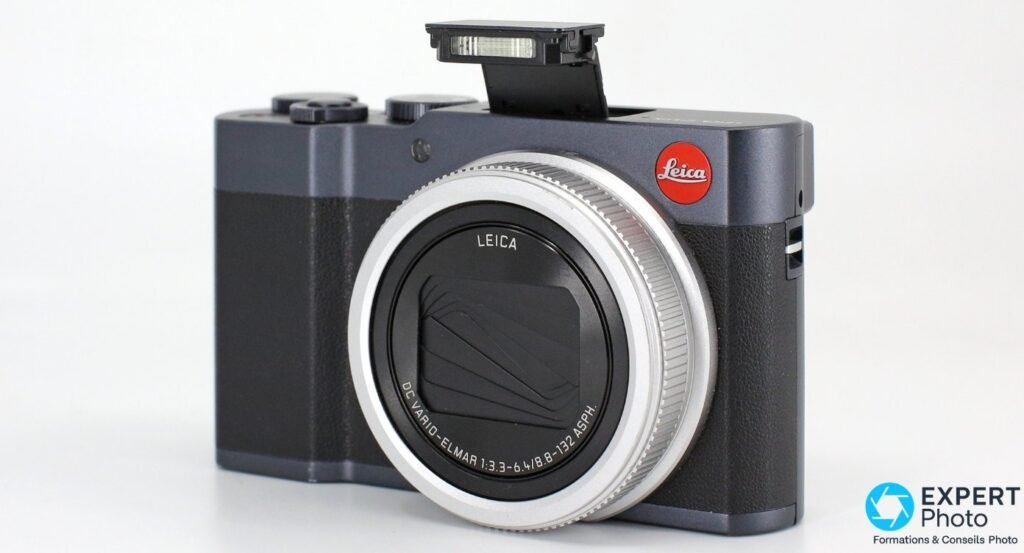 Leica C-Lux de trois-quarts avant, objectif rétracté en position transport, cuir noir et finition Midnight Blue.