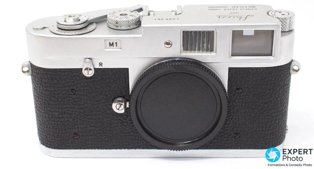 Leica M1 chromé en vue frontale stricte, plaque M1 obturant la fenêtre du télémètre, numéro de série 1 098 261 lisible.