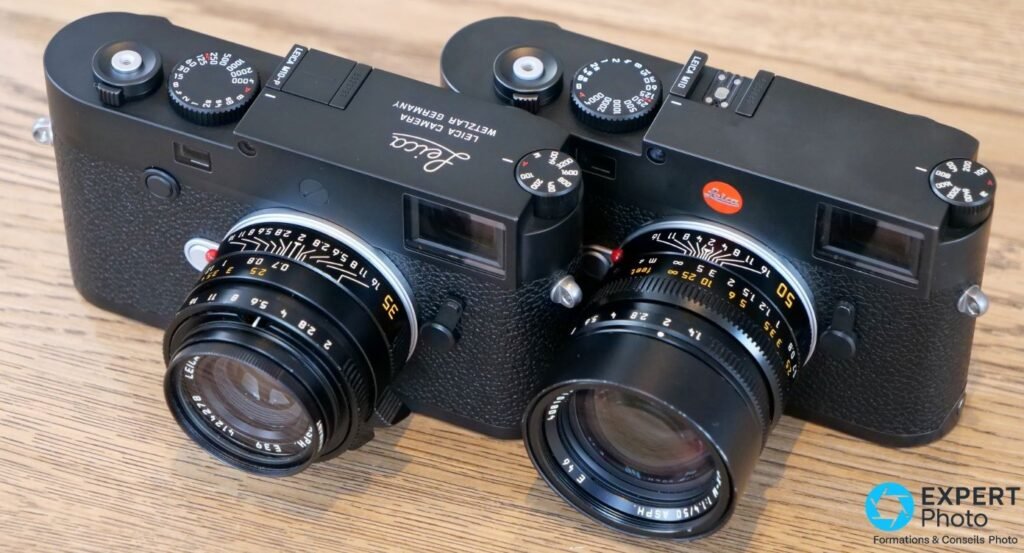 Leica M10-P et Leica M10 côte à côte vus en trois-quarts dessus, l'un sans logo rouge frontal, l'autre avec.