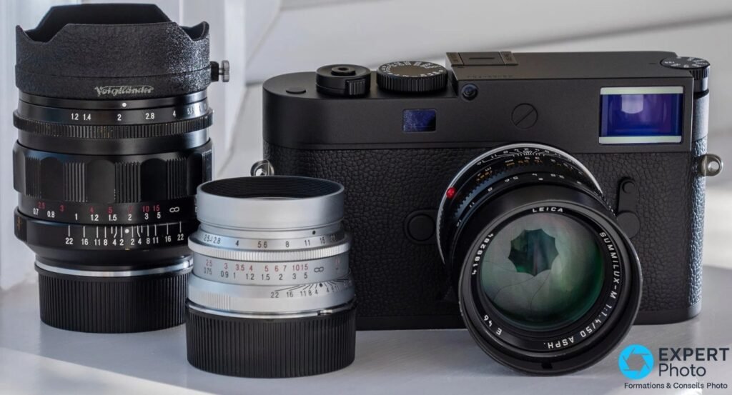  Leica M11 Monochrom et Summilux-M 50 mm à côté d'un Voigtländer 35 mm et d'un troisième objectif M à fût argenté. 