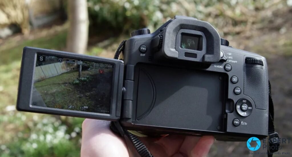 Leica V-Lux Typ 114 vu de dos, écran articulé ouvert avec live view, viseur EVF, commandes Q.Menu, ISO et MENU/SET