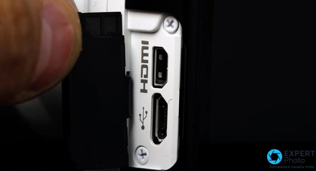 Détail de la trappe latérale ouverte du Nikon 1 J4 avec les ports mini HDMI et micro USB visibles