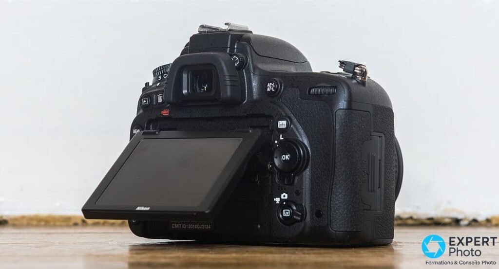 Nikon D750 de dos, écran TFT-LCD inclinable ouvert vers le bas, trappe slot SD visible à droite, boutons AE-L OK Lv 